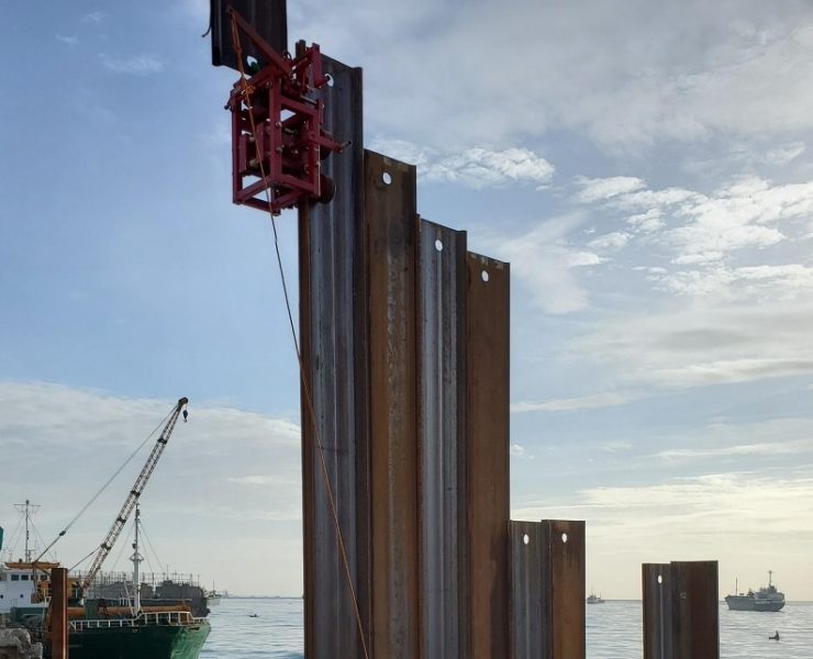 Threader systems guide sheet piles into the correct interlock from ground level, which reduces the chance of misalignment during driving. Ground-release shackles let crews disconnect lifting gear without climbing, which improves safety on marine and land-based piling sites. Photo Credit: Stab Cat, Inc.