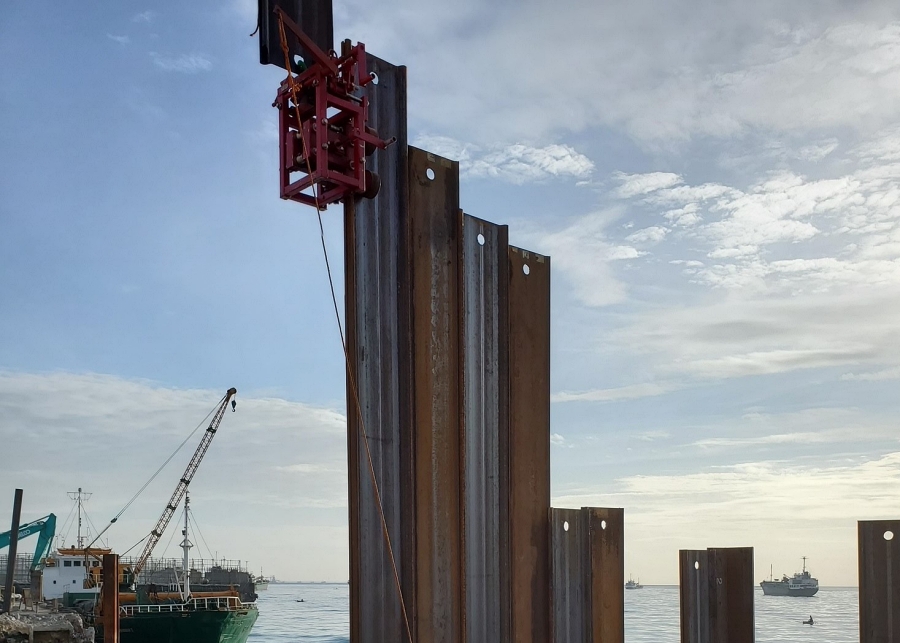 Threader systems guide sheet piles into the correct interlock from ground level, which reduces the chance of misalignment during driving. Ground-release shackles let crews disconnect lifting gear without climbing, which improves safety on marine and land-based piling sites. Photo Credit: Stab Cat, Inc.