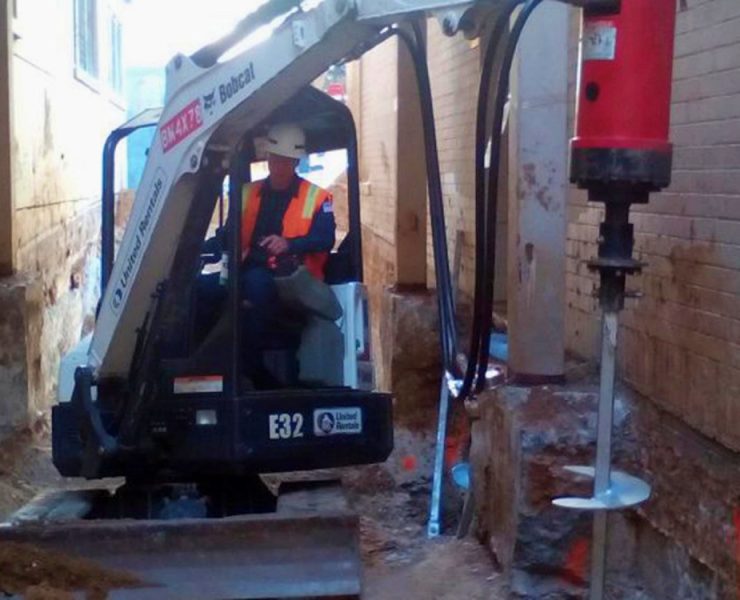 Helical piles provide immediate load bearing support because they do not require curing time and can be installed in active commercial or industrial facilities. Their torque based installation method offers predictable capacity confirmation during every project. Photo Credit: EagleLIFT, Inc.