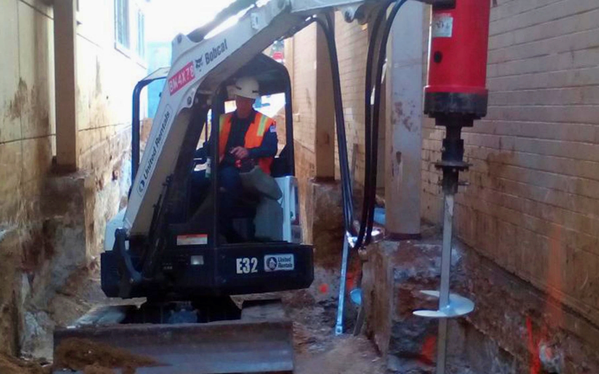 Helical piles provide immediate load bearing support because they do not require curing time and can be installed in active commercial or industrial facilities. Their torque based installation method offers predictable capacity confirmation during every project. Photo Credit: EagleLIFT, Inc.