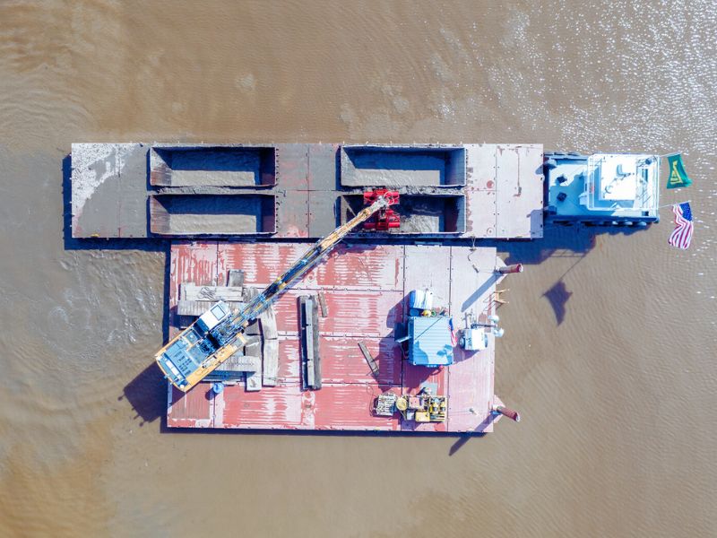 Modern marine construction relies on specialized barges and dredging vessels like these to transport materials and equipment for pile driving and waterfront foundation projects. Such fleets make it possible to build stable, long-lasting marine structures in rivers, harbors, and coastal zones. Photo Credit: Veit