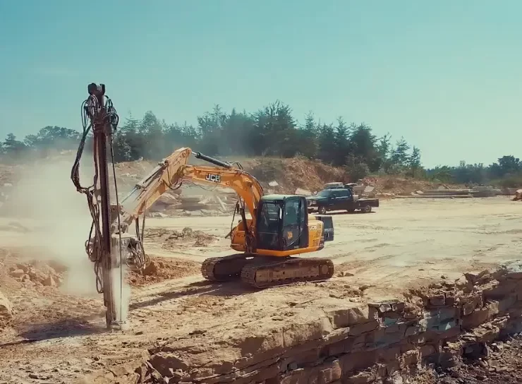 Excavator mounted drilling attachments offer greater reach and positioning control on uneven or restricted access sites. Their versatility allows contractors to use existing fleet equipment without costly replacements. Photo Credit: WORD Rock Drills