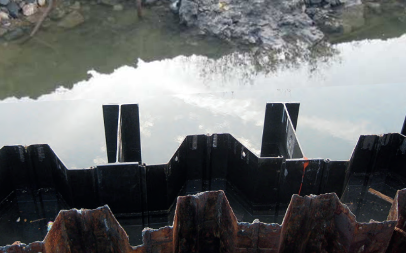 Hybrid H-pile and sheet pile walls use structural king piles to carry most bending forces while intermediary sheet piles transfer earth and water pressures. This load sharing significantly increases wall stiffness compared to conventional sheet pile systems. Photo Credit: Steelwall ISH GmbH