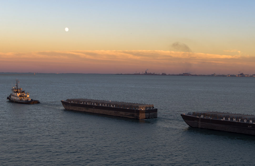 Water-based transport can move significantly more material per trip compared to trucks, lowering fuel use per ton. This efficiency helps coastal construction projects manage costs while reducing environmental impact. Photo Credit: Ashton Marine