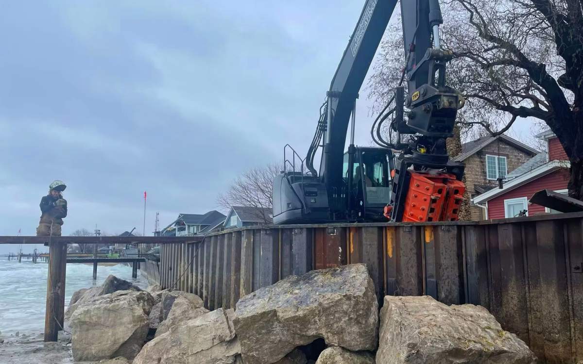 Hybrid steel and armor stone breakwalls allow wave energy to be reduced before it reaches the main structural wall, which helps limit erosion and foundation scour. This layered approach increases the service life of shoreline protection systems compared to single-material concrete walls. Photo Credit: Warkentin Fabricating