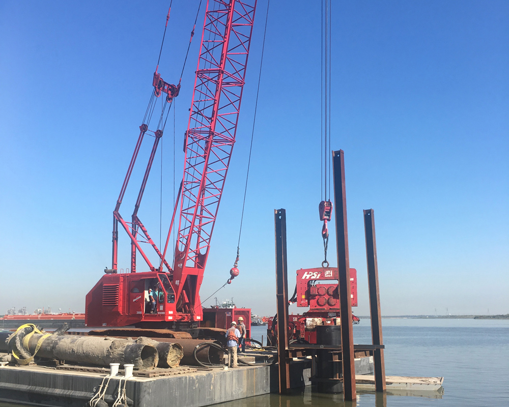 Marine piles must handle both vertical loads from equipment and horizontal forces from vessels, waves, and currents. Fabricated steel parts often need field measurements because pile positions and older waterfront structures may not exactly match the drawings. Photo Credit: Taylor Marine Construction